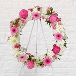 Baby pink and white flowers round wreath with white stand