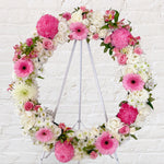 Baby pink and white flowers round wreath with white stand