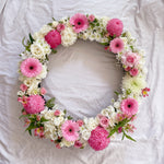 Baby pink and white flowers round wreath with white stand