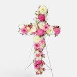 Baby pink and white flowers cross wreath on white stand