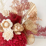 A mix of preserved flowers and silk flowers of hydrangea, Italian ruscus, silk flower, fox tail, palm arranged in a in white vase.