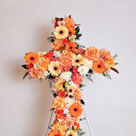 Orange flowers cross wreath with white stand