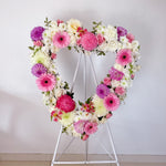Pink & Lilac Heart Wreath featuring seasonal pink and lilac flowers - roses, gerberas, baby's breath, chrysanthemum, alstromerias, dahlias, greenery