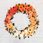 Two toned orange, yellow and white flowers round wreath featuring seasonal flowers - roses, gerberas, dahlias, chrysanthemums, tiger lilies, princess lily, greenery