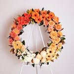 Two toned orange, yellow and white flowers round wreath featuring seasonal flowers - roses, gerberas, dahlias, chrysanthemums, tiger lilies, princess lily, greenery