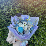 blue bouquet featuring blue and white flowers - roses, chrysanthemum, Delphinium, gerberas, lisianthus, eucalyptus.