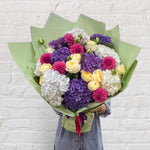 bright and vibrant seasonal bouquet with blue and white hydrangeas, pink dahlias and cream roses