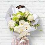 A beautiful bouquet of flowers in greens and whites with hydrangeas, eucalyptus, chrysanthemums, columbian roses, Phalaenopsis orchid. Flower delivery Sydney. Sydney Florist.