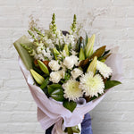 green & white bouquet featuring seasonal flowers - roses, snap dragons, lilies, disbuds, greenery.