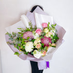 purple bouquet featuring seasonal flowers - roses, chrysanthemum, stock, eucalyptus and eucalyptus