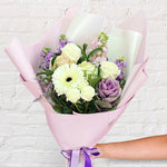 purple bouquet featuring gerbera, roses, stock, kale & misty