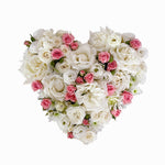 white filled heart wreath featuring seasonal flowers - roses, spray roses, chrysanthemum.