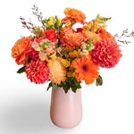 Orange flowers vase arrangement in pink vase