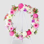 Soft pink and lilac round wreath with white stand