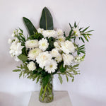 Seasonal white and green flowers in a glass vase. Corporate flowers