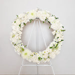 white flowers round wreath with stand 