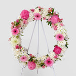 Baby pink and white flowers round wreath with white stand
