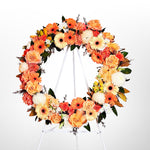 Orange Round Wreath featuring seasonal flowers - gerberas, dahlias, spray roses, roses, tiger lily, snap dragon, chrysanthemum, greenery. 