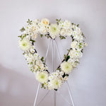 White flowers heart wreath featuring roses, dahlias, chrysanthemum, lisianthus, greenery. 