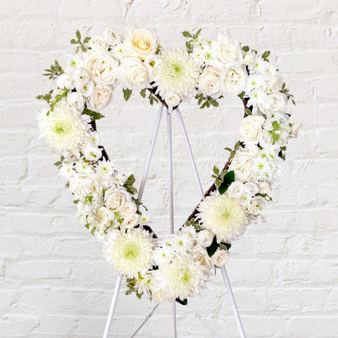 White flowers heart wreath featuring roses, dahlias, chrysanthemum, lisianthus, greenery. 
