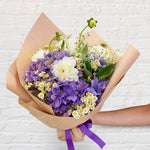 blue bouquet featuring blue and white flowers - hydrangeas, chamomile, dahlia. 