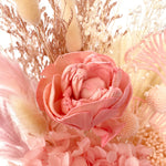 A mix of preserved flowers and silk flowers of hydrangea, Italian ruscus, bunny tails, baby's breath, rice flower, peony flower, palm and fluffy stick in a in white vase.