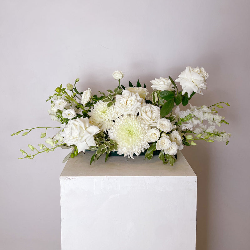 white & greens table centerpiece featuring seasonal flowers - roses, disbuds, Singapore orchid, spray roses, greenery, snap dragons. 